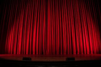 red theater curtain by Rob Laughter courtesy of Unsplash.